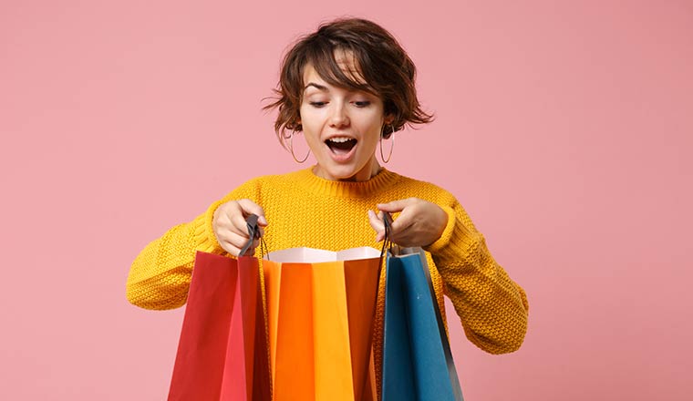 Happy person looking into shopping bags