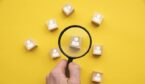 Magnifying glass over wooden blocks with people