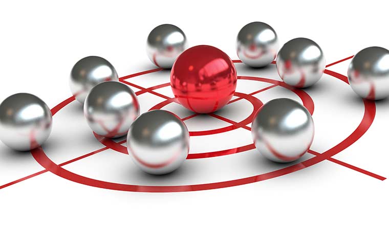 A red ball in the centre of a target surrounded by grey balls