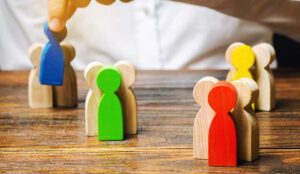 Groups of multicolored wooden people being sorted