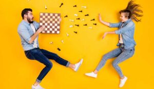 Two people jumping with a chess board representing important skills