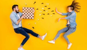 Two people jumping with a chess board representing important skills