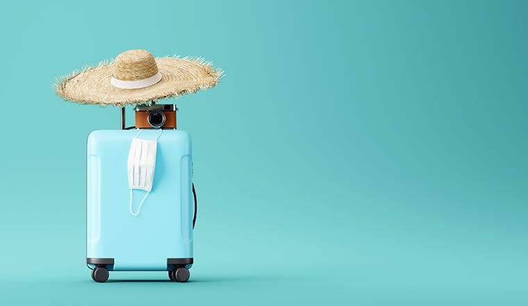 A blue suitcase with face mask and travel accessories