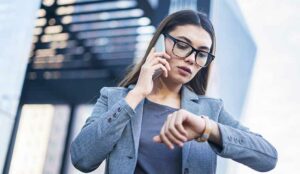 Person talking on phone and checking watch