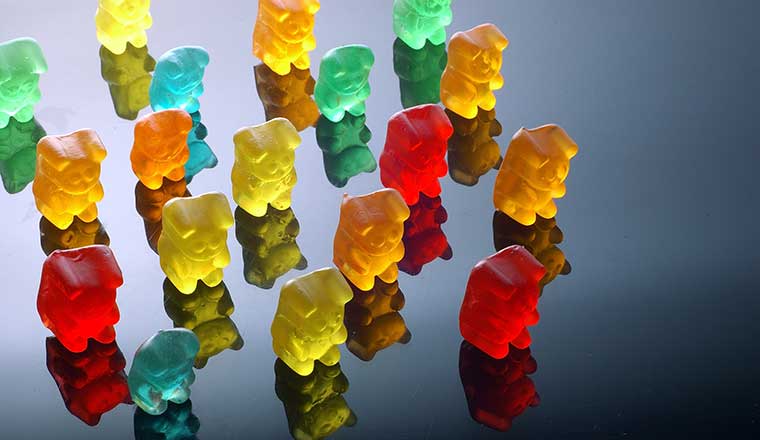 Gummy bears lined up and facing the same direction in a group