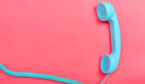 Retro phone on a pink paper background