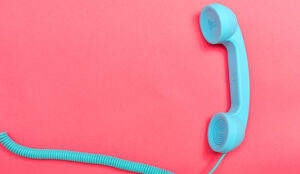 Retro phone on a pink paper background