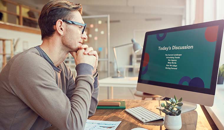 man sitting at a computer for a webinar