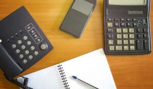 Phone, calculator and pen on desk