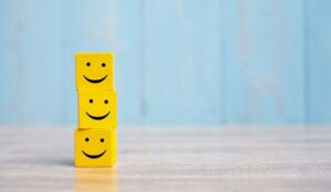 Three stacked smiley face cubes representing customer satisfaction