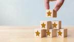 Hand arranging wood block stacking as step stair with five star shape