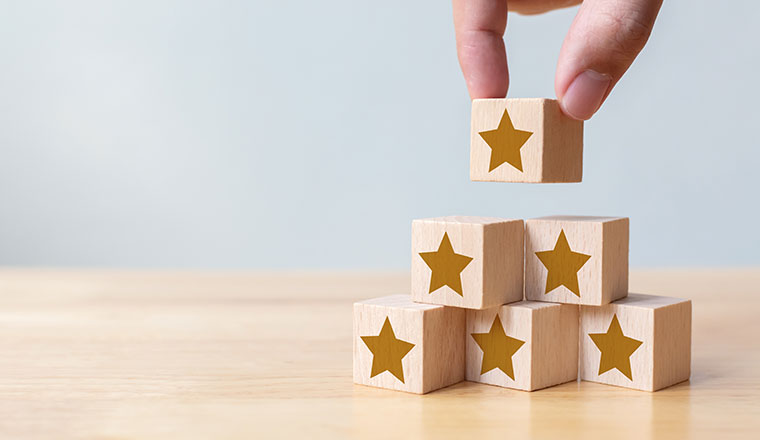 Hand arranging wood block stacking as step stair with five star shape