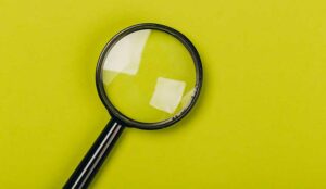 Small magnifying glass on green background