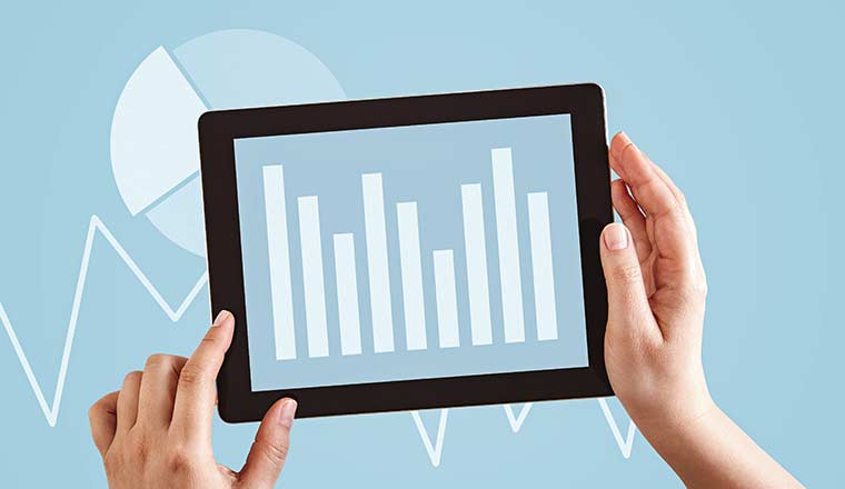 Hands using tablet computer analyzing business trend graphs