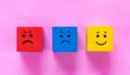 Red, blue and yellow cubes with upset to happy faces