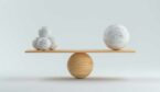 Wooden scale balancing one big ball and four small ones