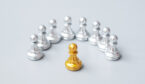 A golden chess pawn pieces or leader stand out of crowd people of silver