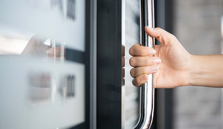 A hand holding the door bar to open the door