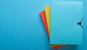 top view of colorful paper binders isolated on blue