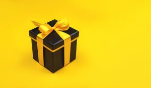 One black gift box on yellow background.