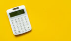 A white calculator on yellow background