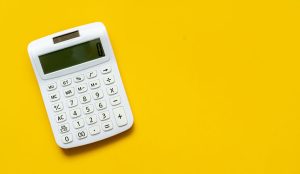 A white calculator on yellow background