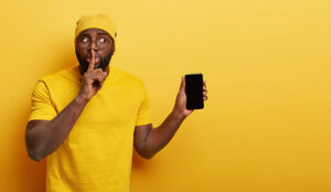 Person holding phone making shh gesture