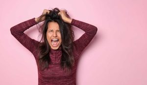 Frustrated person on pink background