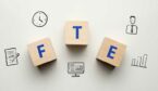 Acronym FTE or Full Time Equivalent. Text on wooden cubes.