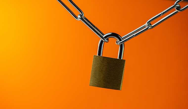 Padlock Connecting a Metal Chain on an Orange Background