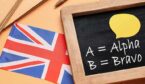 Stationery, chalkboard and UK flag on color background with words