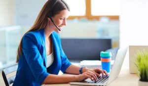 Engaged employee working at desk with headset and laptop