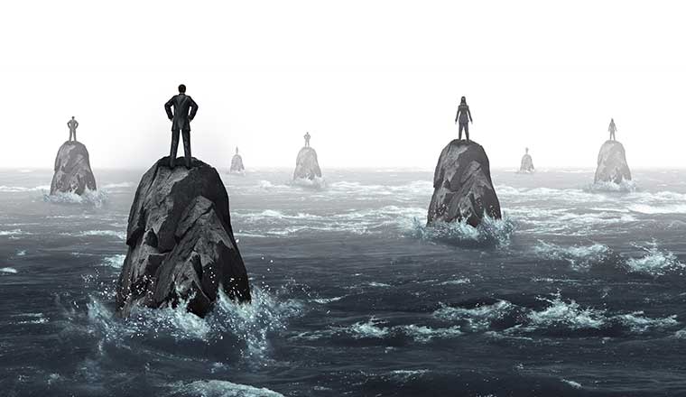 people stood on rocks in the sea