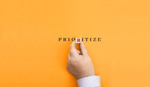 Hand makes up the word "prioritize" from letters