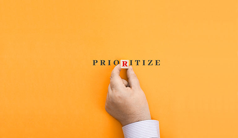 Hand makes up the word "prioritize" from letters