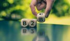 Hand turns a dice and changes the expression "B2B" to "B2C"