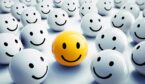 A yellow happy face standing out in crowd of others - customer experience concept