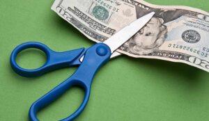 Cutting Costs concept with scissors and bank note