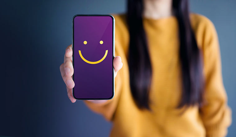 Customer Experience Concept, happy person shows smiley face on phone