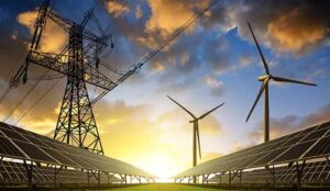 Solar panels with wind turbines and electricity pylon at sunset.