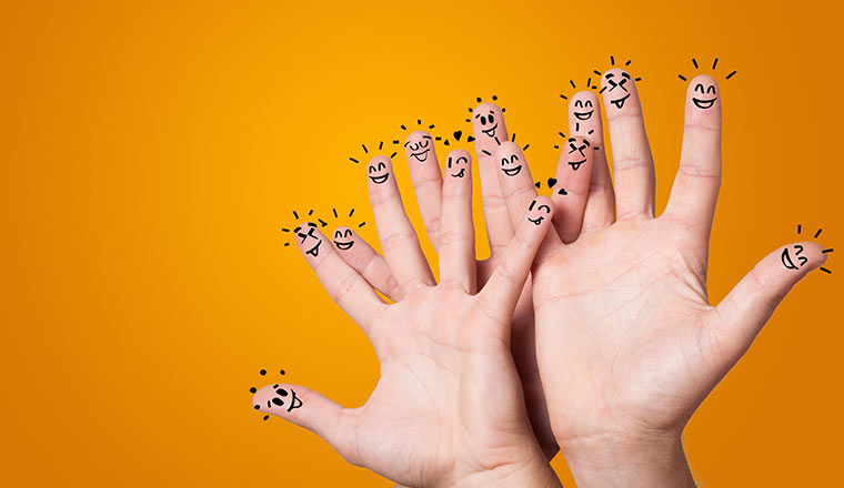 Three hands with happy faces on fingers