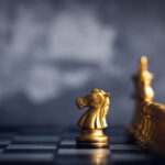 chess piece stand in front of pawn on black background