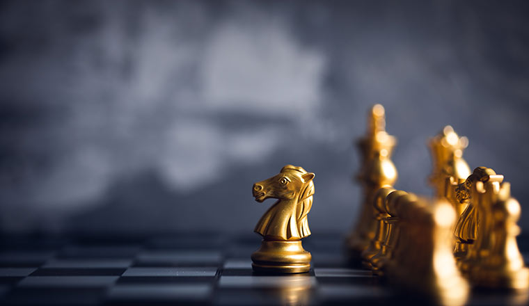 chess piece stand in front of pawn on black background