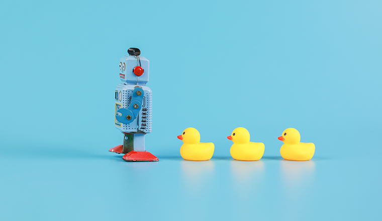 Leadership concept with robot ahead of rubber ducks