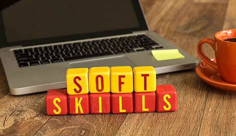 Soft Skills written on a wooden cube in a office desk