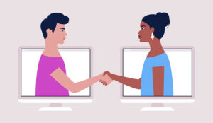 Two people coming out of computer screens shaking hands