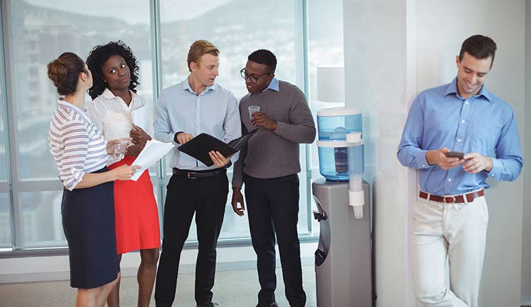 Business colleagues discussing by water cooler