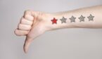 hand showing thumbs down and one star rating on the arm