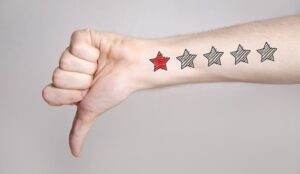 hand showing thumbs down and one star rating on the arm