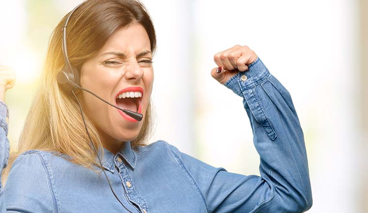 A call center worker in headphones happy and excited celebrating victory